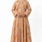 Woman wearing an orange floral dress with a matching hijab on a white background