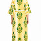 Woman wearing a yellow and green patterned dress on a white background