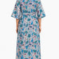 Woman wearing a long floral dress with a white background