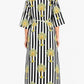 Woman wearing a black and white striped dress with palm tree patterns on a white background