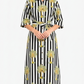 Woman wearing a black and white striped dress with yellow floral patterns on a white background
