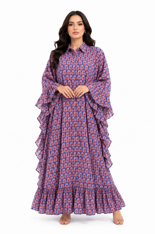 Front view of a model wearing a full length blue and red block print kaftan maxi dress featuring dramatic ruffle sleeves and a collared button down front