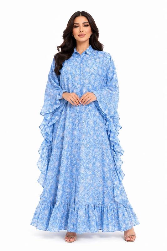 Woman wearing a blue floral dress with ruffled layers on a white background