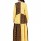 Woman wearing a yellow and brown patterned dress on a white background