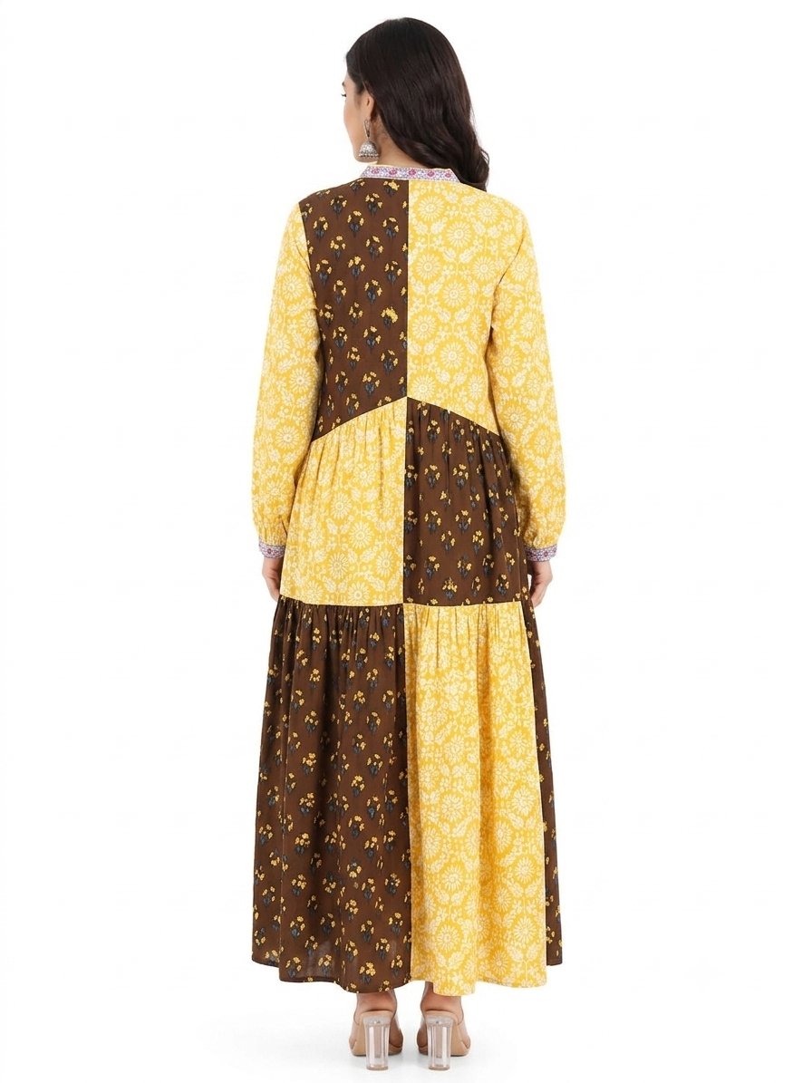 Woman wearing a yellow and brown patterned dress on a white background