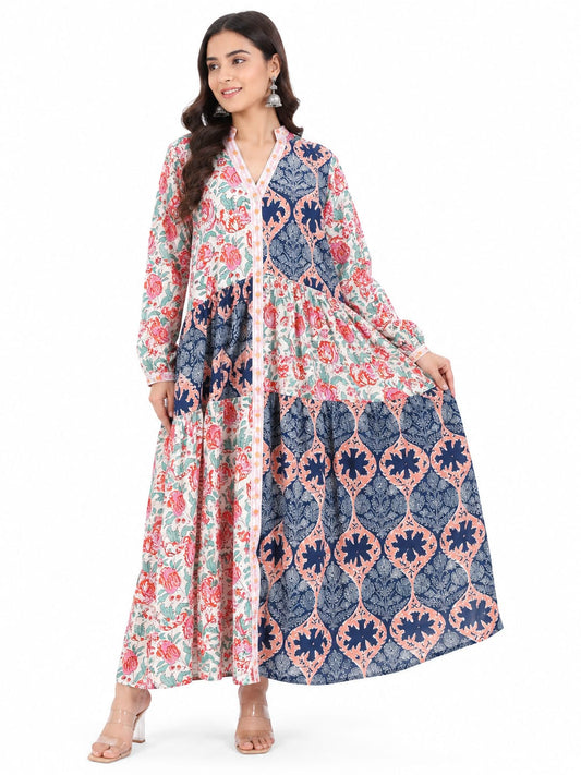 Woman wearing a long, patterned dress with floral and geometric designs on a white background