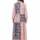 Woman wearing a long, patterned dress with a white background