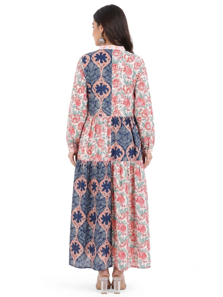 Woman wearing a long, patterned dress with a white background