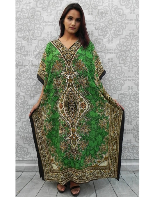 Woman wearing a green patterned dress against a white wall.