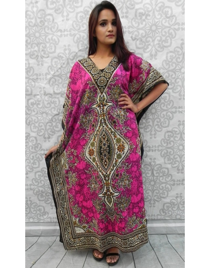 Woman wearing a pink and black patterned dress against a white wall.